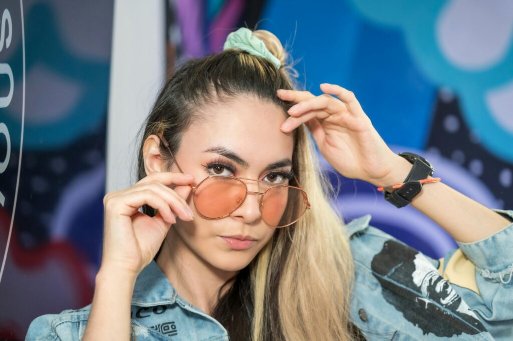 A woman in denim jacket and sunglasses